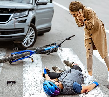 Cycliste renversé sur la route par une voiture. Léo Ciochetti, avocat des victimes d'accident de la circulation, Paris.